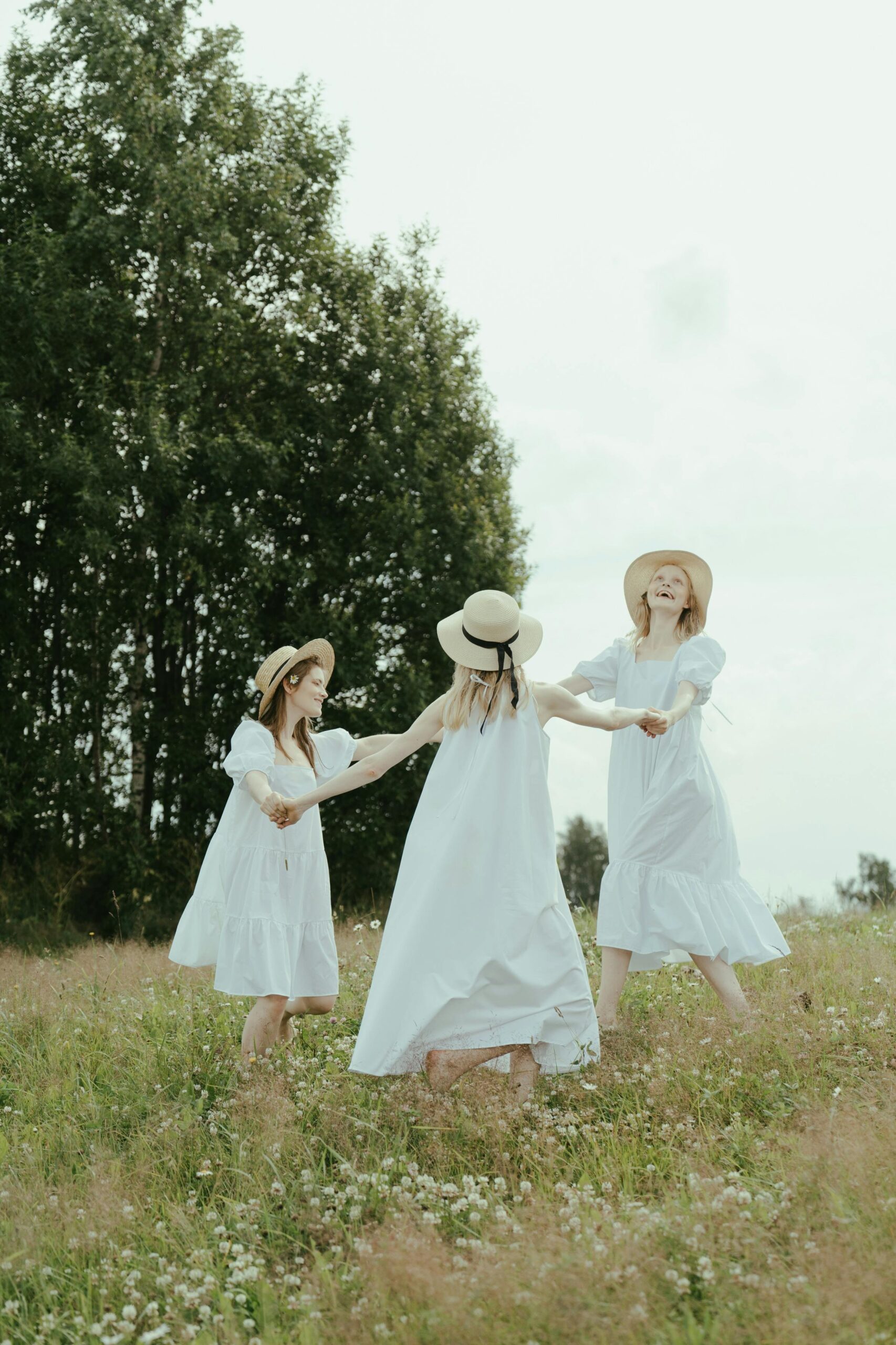 A group of beginner witches in a white dresses dancing in celebration of Spring